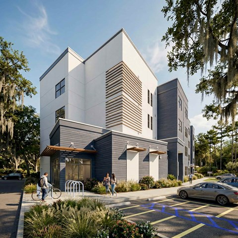 A modern building with a parking lot in front.