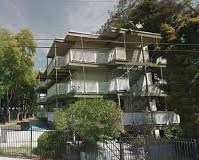 A large, multi-level house with a balcony on the upper floor.