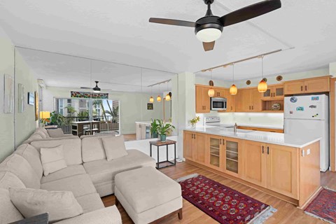 A living room with a couch and a ceiling fan.