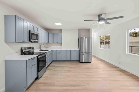 A kitchen with a refrigerator, microwave, and oven.