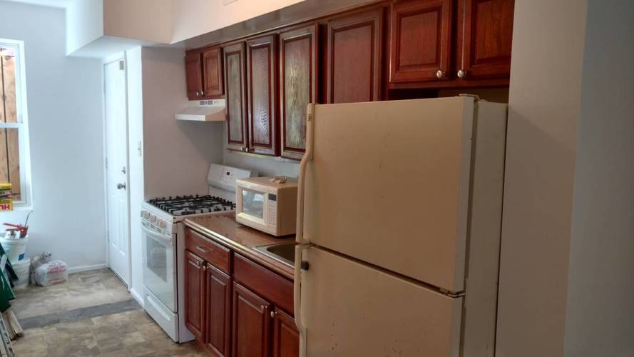 A kitchen with brown cabinets and a white fridge.