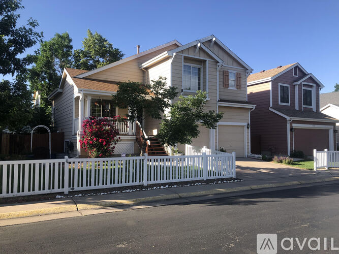 A white picket fence separates two houses.