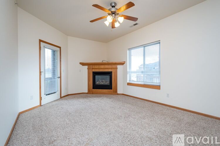 A living room with a fireplace and a ceiling fan.