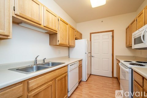 A kitchen with wooden cabinets and white appliances.