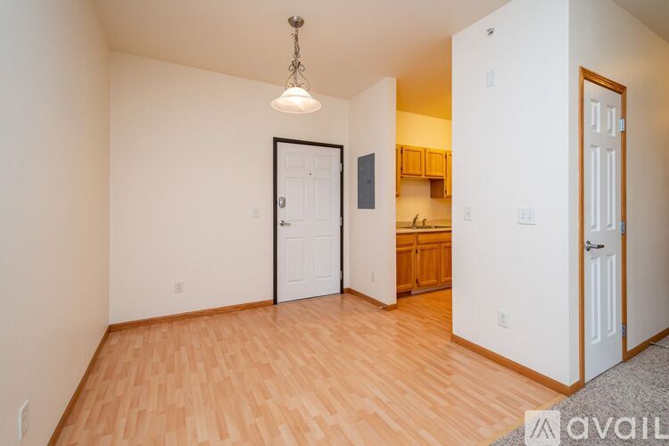 A room with wooden floors and a chandelier hanging from the ceiling.