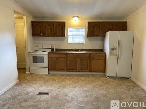 A kitchen with wooden cabinets and a white refrigerator.