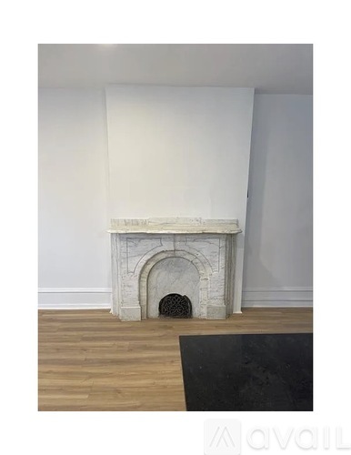 A white fireplace with a black rug in front of it.