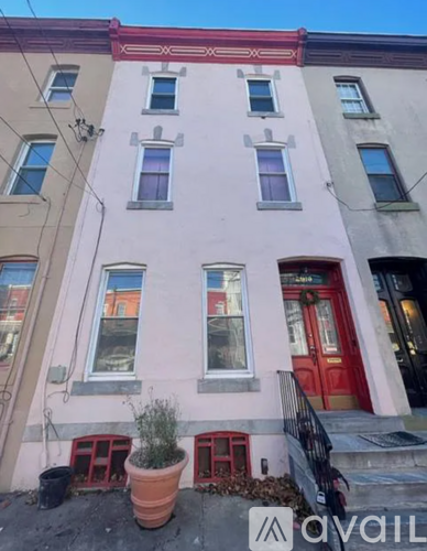 A building with a red door and a balcony with a railing.