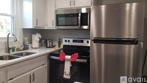 A modern kitchen with a stainless steel refrigerator and a black oven.