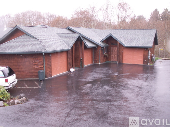 A wet parking lot in front of a brick building.