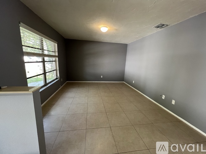 A room with a large window and tiled floor.