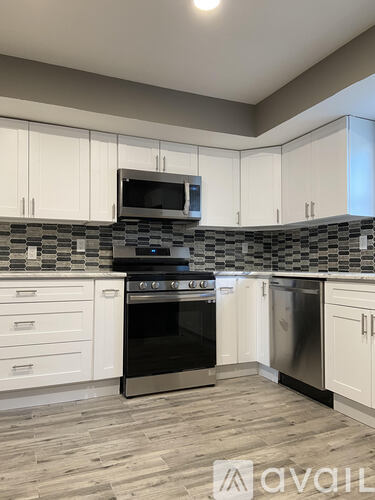 A kitchen with a black oven and white cabinets.