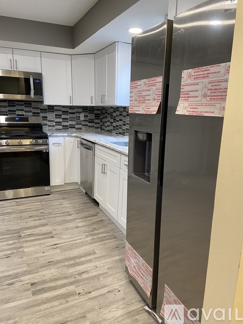 A kitchen with a refrigerator covered in red and white paper.