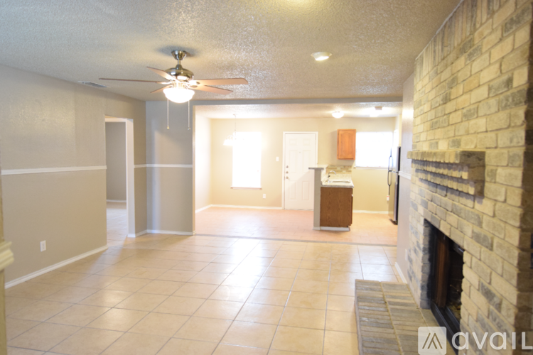 A spacious room with a fireplace on the right side.