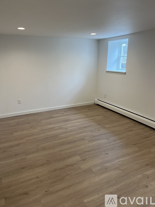 A room with wooden flooring and a window.