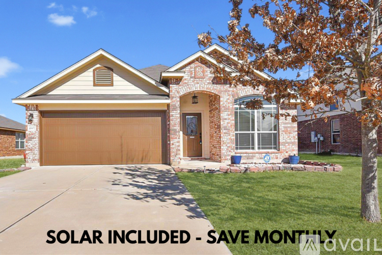 A house with a brown garage door and solar panels on the roof.
