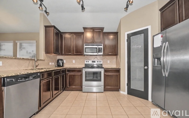 A kitchen with brown cabinets and stainless steel appliances.