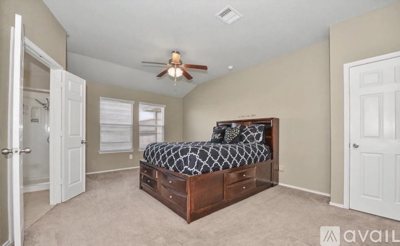 A bedroom with a bed, dresser, and ceiling fan.