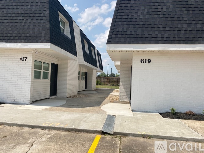 Two white houses with black roofs and numbers 617 and 619 on them.