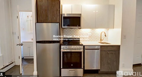 A kitchen with a stainless steel refrigerator, oven, and microwave.