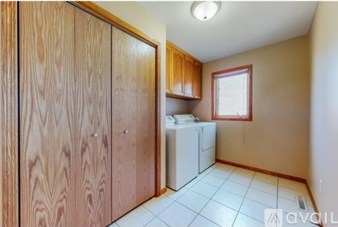 A small kitchen with wooden cabinets and a white fridge.