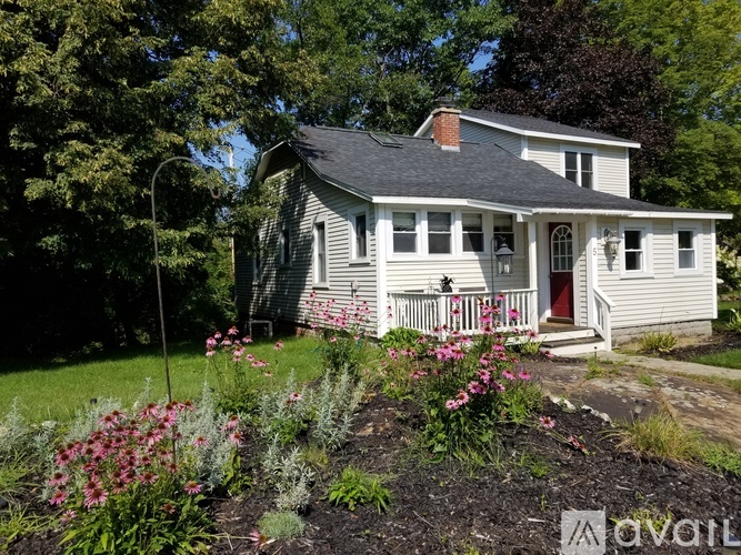 A house with a red door and a porch with a white railing.