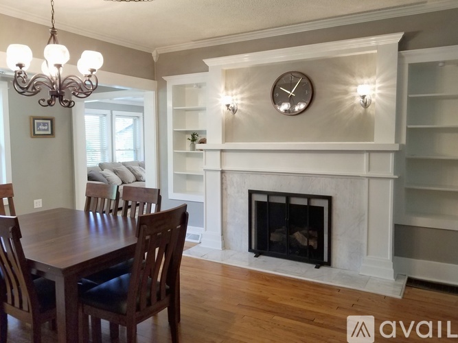A dining room with a fireplace and a chandelier.