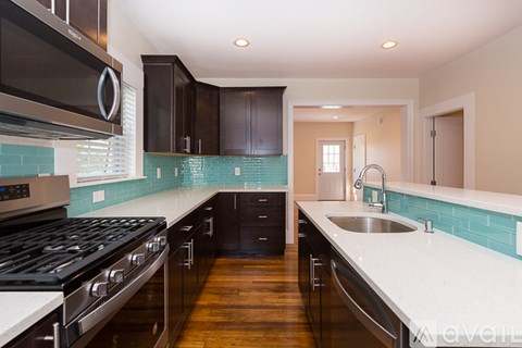 A kitchen with a stove top oven and a sink.