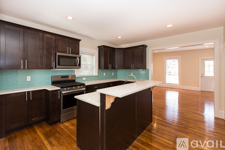 A kitchen with dark wood cabinets and a white counter top.