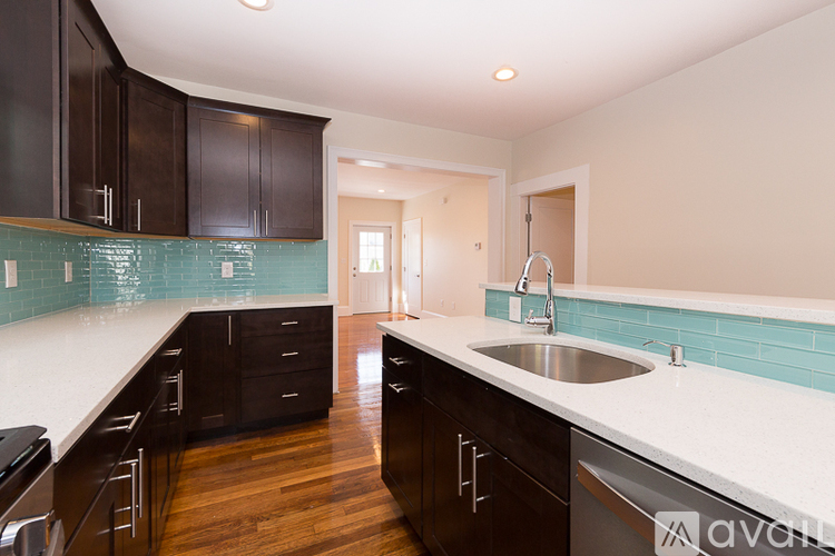 A kitchen with dark wood cabinets and a white counter top.
