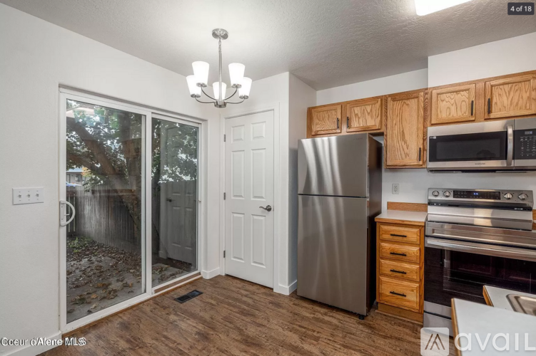 A kitchen with a refrigerator, microwave, oven, and sink.