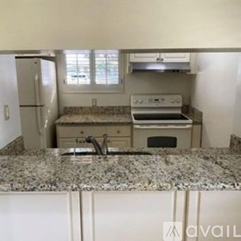 A kitchen with granite countertops and stainless steel appliances.