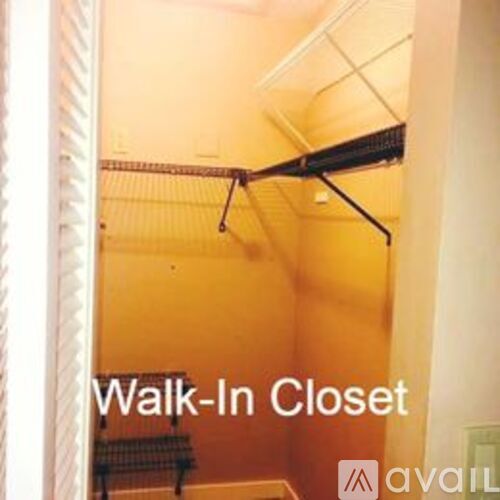A walk-in closet with clothes hanging on a rack.