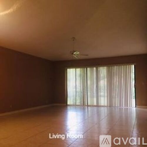 A living room with a fan and sliding glass doors.
