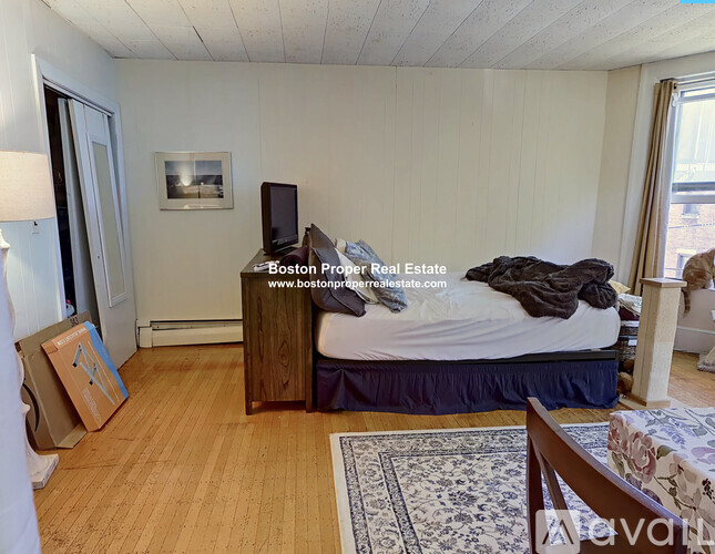 A bedroom with a bed, dresser, and a painting on the wall.