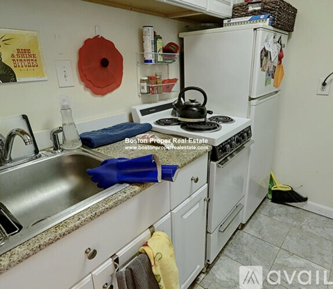 A kitchen with a stove, sink, and refrigerator.