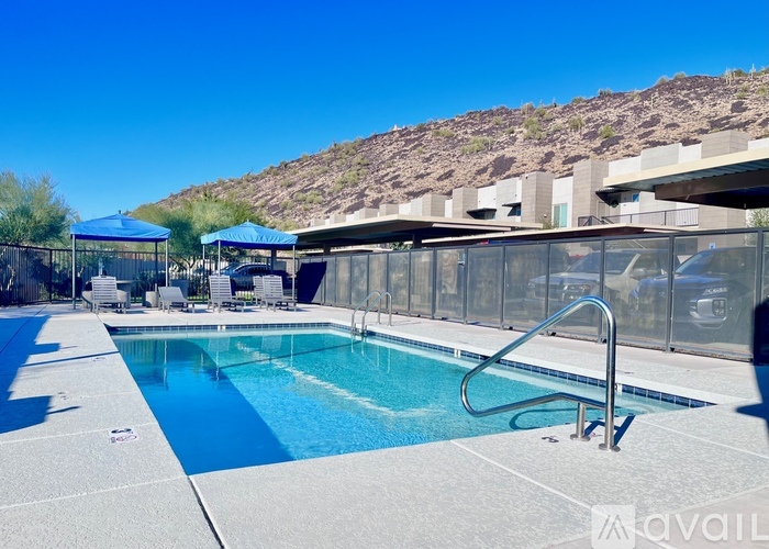 A pool with a slide and a mountain in the background.