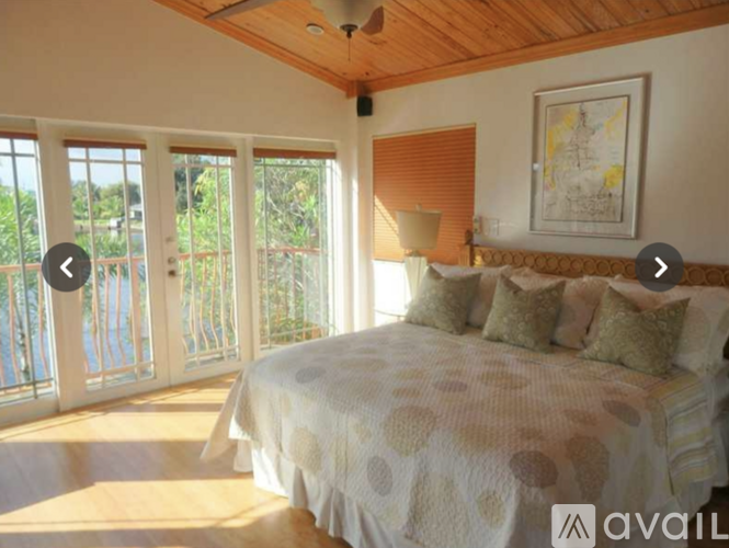 A bedroom with a large bed and a balcony.