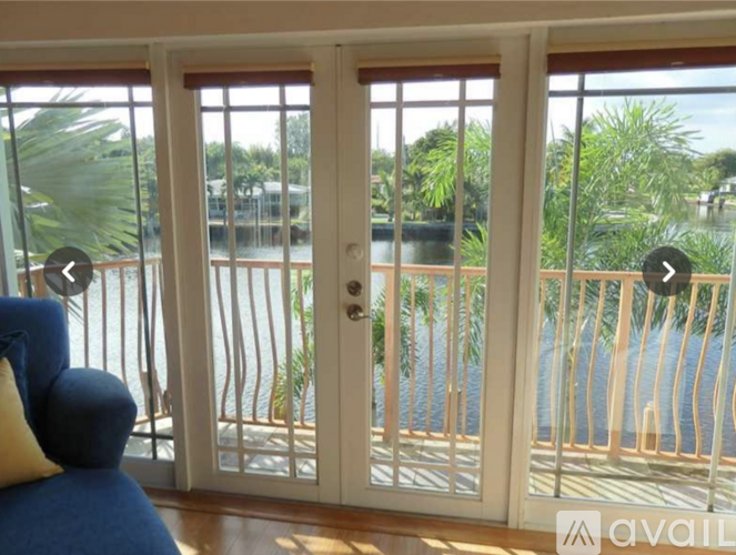 A balcony with a view of a pool and palm trees.