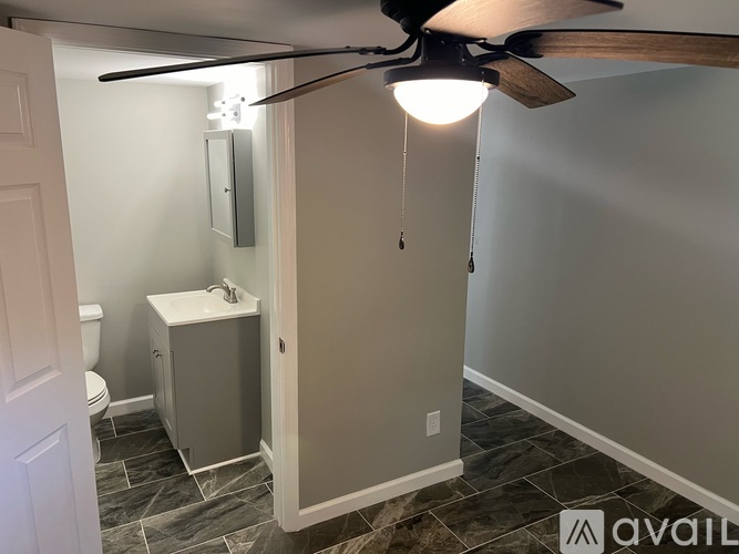A bathroom with a fan and a cabinet.