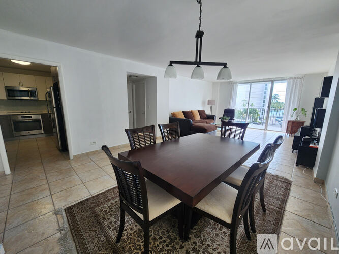 A dining room with a large table and chairs.