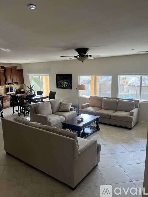 A living room with a large couch and a ceiling fan.