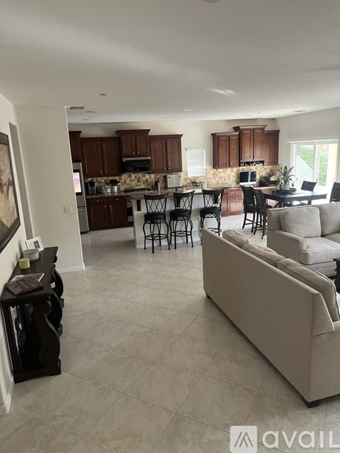 A living room with a couch, chairs, and a dining table.