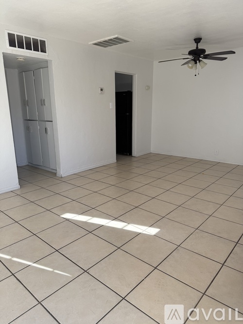 A room with a ceiling fan and a white tile floor.