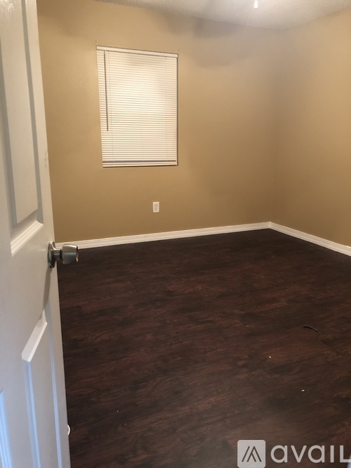 A room with a white door and a window with blinds.