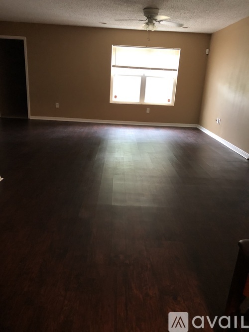A room with a window and wooden flooring.