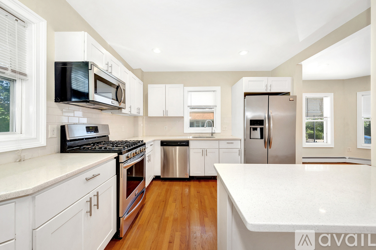 A kitchen with white cabinets and a white counter top.