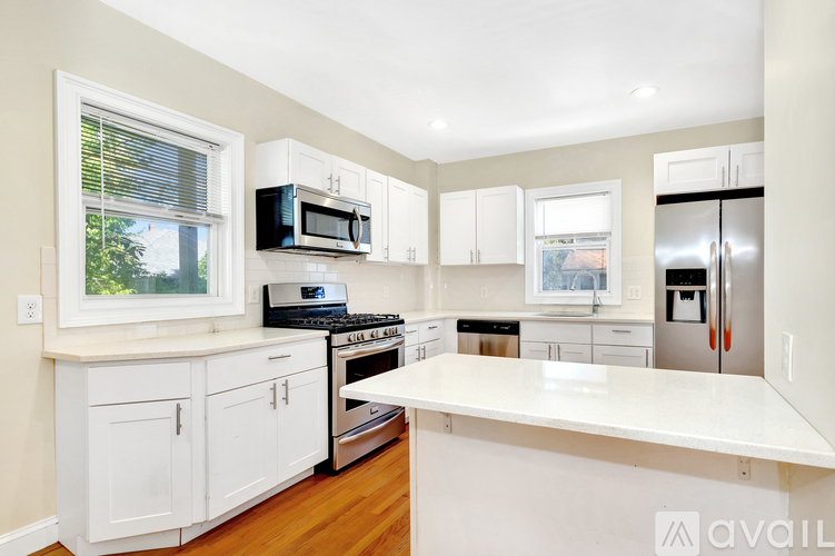 A kitchen with white cabinets and appliances.