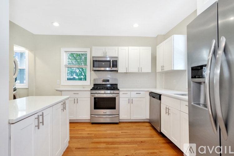 A modern kitchen with white cabinets and stainless steel appliances.