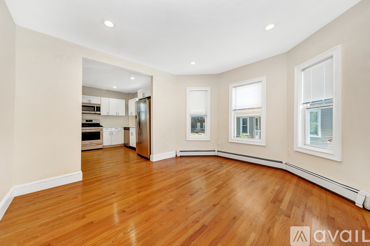 A spacious room with wooden floors and white walls.